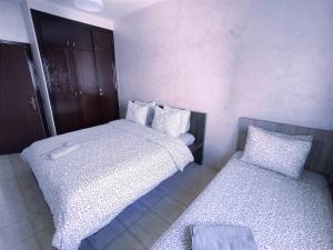two beds in a small room withermottermottermottermott at rabatapartmentresidence in Rabat +2 photos