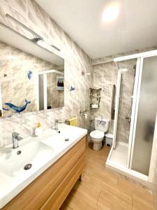 een badkamer met een wastafel, een douche en een toilet bij Infantes Beach Apartment in Torre del Mar