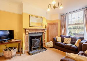 a living room with a couch and a fireplace at Bond Cottage in Overstrand
