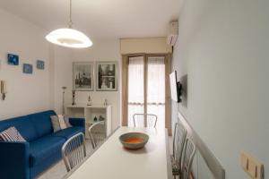 ein Wohnzimmer mit einem blauen Sofa und einem Tisch in der Unterkunft Appartamento CI in Follonica