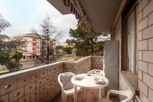 einen Balkon mit einem Tisch und Stühlen sowie einem Fenster in der Unterkunft Appartamento CI in Follonica