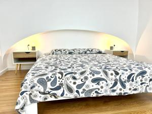 a bedroom with a large bed with a black and white bedspread at Andrea's 12 in Bari