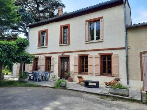 une maison avec une table et des chaises devant dans l'établissement Maison de campagne avec jardin, à Montauban