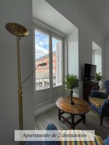 a living room with a table and a large window at Plaza Mayor in Madrid
