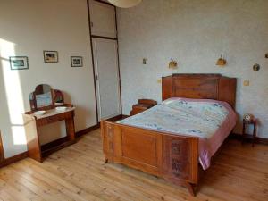 - une chambre avec un lit en bois, une commode et un miroir dans l'établissement Maison de campagne avec jardin, à Montauban 20 autres photos