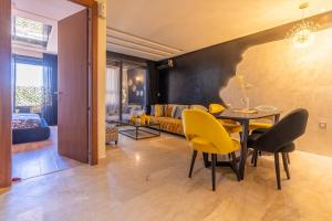 La terrasse d'Audrey - Short stay au coeur du Maarif في الدار البيضاء: غرفة معيشة مع طاولة طعام وكراسي صفراء