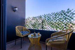 2 sillas y una mesa con gafas en el balcón en La terrasse d'Audrey - Short stay au coeur du Maarif, en Casablanca