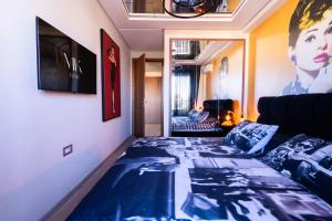 Habitación con cama con sábanas azules y sofá. en La terrasse d'Audrey - Short stay au coeur du Maarif, en Casablanca