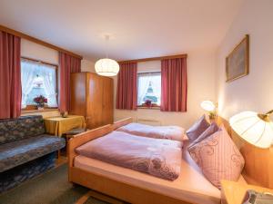a hotel room with a bed and a couch at Chalet - Appartements Julitta in Mayrhofen