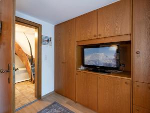 a room with a flat screen tv in a wooden cabinet at Chalet - Appartements Julitta in Mayrhofen