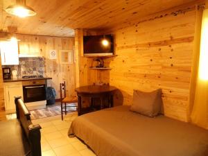 1 dormitorio con 1 cama y pared de madera en La Caverne du Buisson, en Truffe