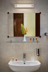 a bathroom with a white sink and a mirror at Dunia Hôtel Bissau in Bissau