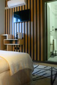 um quarto com uma cama e uma televisão na parede em Boutique Wine Hotel Panorama em Macedo de Cavaleiros