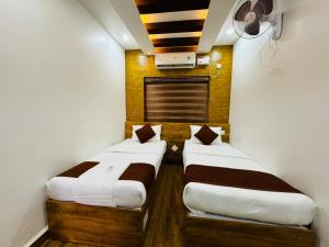 duas camas num quarto com branco e castanho em HERITAGE HOMES em Ernakulam