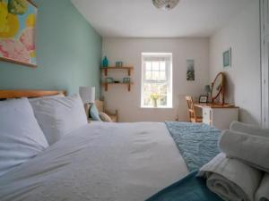 - une chambre avec un lit blanc et une fenêtre dans l'établissement Pass the Keys Stylish and Spacious Cotswolds Cottage - Sleeps 6, à Lechlade