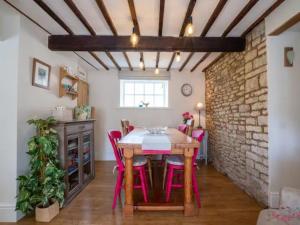 une salle à manger avec une table et des chaises rouges dans l'établissement Pass the Keys Stylish and Spacious Cotswolds Cottage - Sleeps 6, à Lechlade