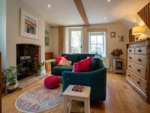 sala de estar con sofá verde y chimenea en Pass the Keys Stylish and Spacious Cotswolds Cottage - Sleeps 6, en Lechlade
