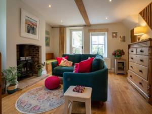 a living room with a green couch and a fireplace at Pass the Keys Stylish and Spacious Cotswolds Cottage - Sleeps 6 in Lechlade