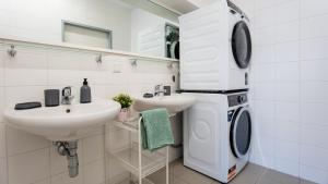 a bathroom with a washing machine and a sink at Zimmer 1230 in Vienna