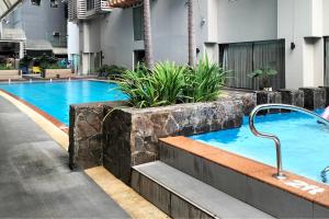 a swimming pool with a hot tub in a building at Fully-furnished Condo Accommodation in Makati in Manila