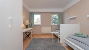 a bedroom with a bed and a desk and windows at Zimmer 1230 in Vienna