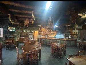 un restaurante con mesas y sillas de madera y un bar en Venta Celta, en O Cebrero