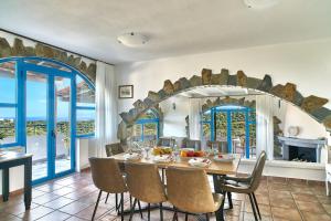 a dining room with a table and chairs at Pano Stalos Villas in Stalos