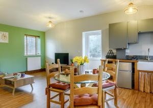 a kitchen and living room with a table and chairs at The Roost - Glen Farm in Thurgarton