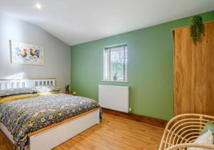 a bedroom with green walls and a bed at The Roost - Glen Farm in Thurgarton
