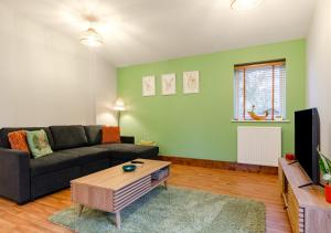 a living room with a couch and a tv at The Roost - Glen Farm in Thurgarton