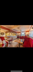 a living room with a red couch and tables at Neptunes Rest Guest Hotel in Stranraer