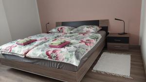 - une chambre avec un lit orné de fleurs roses dans l'établissement Apartma Center, à Bovec