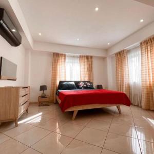 ein Schlafzimmer mit einem großen Bett mit einer roten Decke in der Unterkunft Luxurious Superior Room Space Available in Accra