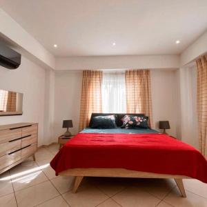 ein Schlafzimmer mit einem Bett mit einer roten Decke und einem Fenster in der Unterkunft Luxurious Superior Room Space Available in Accra