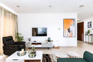 ein Wohnzimmer mit einem Sofa und einem TV in der Unterkunft Luxurious Superior Room Space Available in Accra