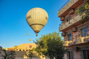 une montgolfière survole un bâtiment dans l'établissement New Memnon Hotel, à Louxor