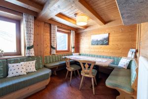 a dining room in a log cabin with a table and chairs at Panorama-Apartments Oberkofl in Cadipietra