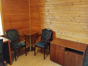 two chairs and a table in a room with wooden walls at Apartmán v dřevěném domě in Františkovy Lázně