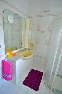 een witte badkamer met een wastafel en een spiegel bij GINESTRA 3 in Marina di Pescoluse
