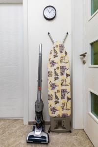 a surfboard leaned up against a wall with a vacuum at Radiant Retreat: Bright 1BD Haven in Plovdiv in Plovdiv