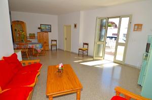 een woonkamer met een rode bank en een tafel bij GINESTRA 3 in Marina di Pescoluse