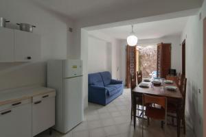 een keuken en eetkamer met een tafel en een blauwe stoel bij Appartamento GIANNUTRI in Follonica