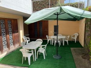 een patio met tafels en stoelen en een parasol bij Appartamento GIANNUTRI in Follonica