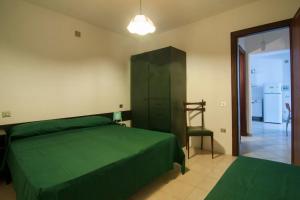 een slaapkamer met een groen bed en een stoel bij Appartamento GIANNUTRI in Follonica