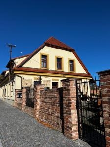 a brick building with a gate in front of it at Penzion LaCasa in Vysoké Mýto