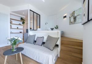 sala de estar con sofá blanco y mesa en MY CASA - PILATTE - BLUE - Beautiful studio on Seafront, en Niza