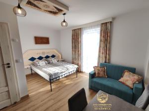 ein Wohnzimmer mit einem Bett und einem Sofa in der Unterkunft Szczawnica Residence "Nad Zdrojami" - In the Heart of Recreation 691-739-603 in Szczawnica