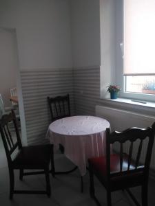 een kamer met een tafel, 2 stoelen en een raam bij Agroturystyka U Puchatka in Rebiszów