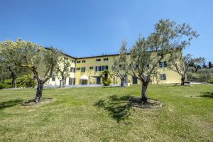 two trees in a field in front of a building at Residence Fontanelle in Cavaion Veronese