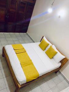 Bett mit gelben Kissen in einem Zimmer in der Unterkunft D15 in Mombasa